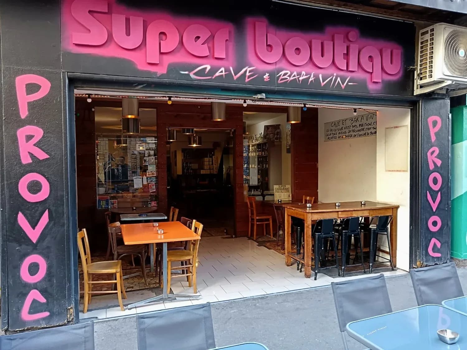 La façade rose et noire de Prov'Oc, ses tables et sa cave ouverte au 8 rue Saint-Michel à Marseille.