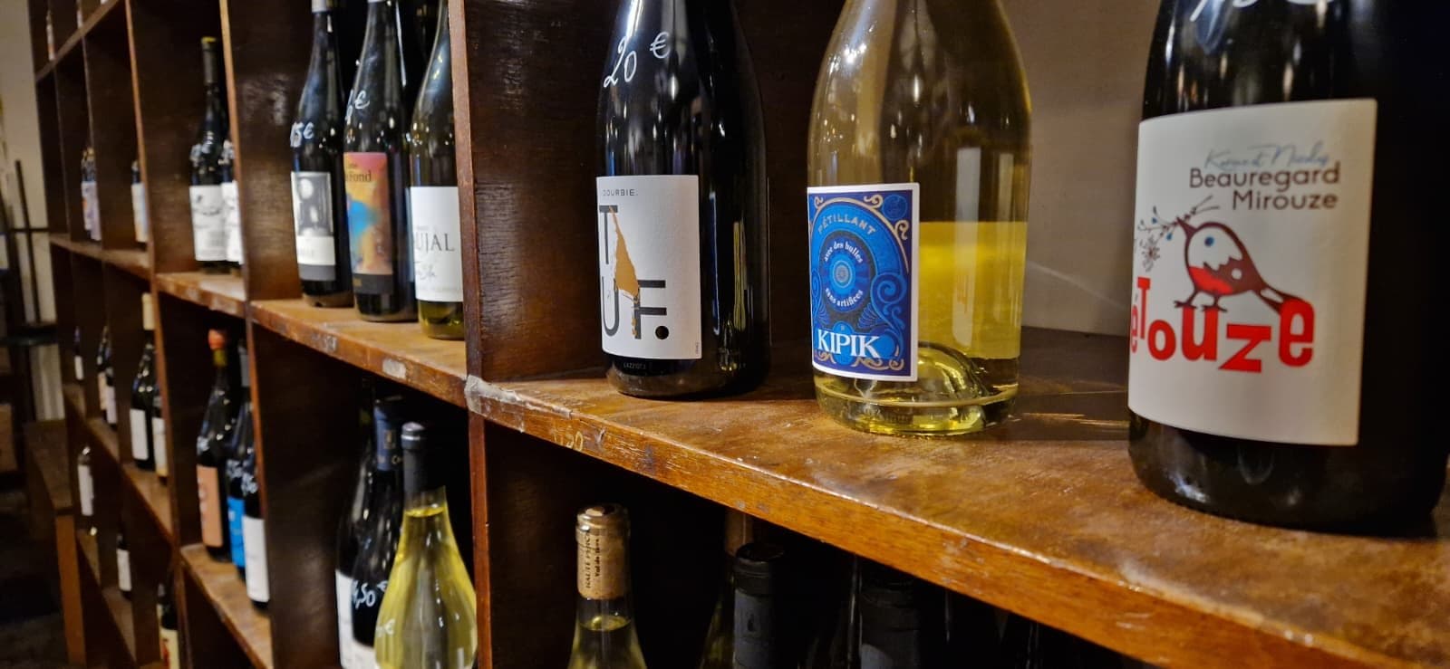 Vitrine en bois de Prov'Oc avec plusieurs bouteilles de vin de vignerons.